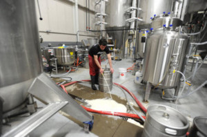 Cellerman David Cox, of Taylor, hand fills a keg inside Brew Detroit LLC's 61,000 sq. foot brewery