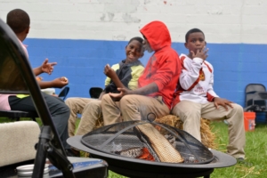 MACC Residents sit around a fire at CD's "Real Talk on MACC" event.